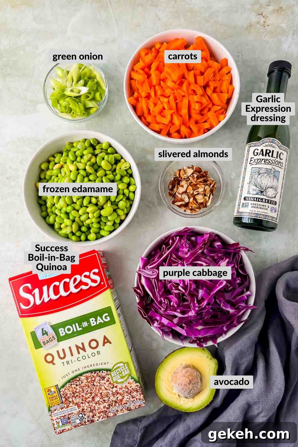 ingredients for quinoa edamame salad in individuals bowls on grey background.