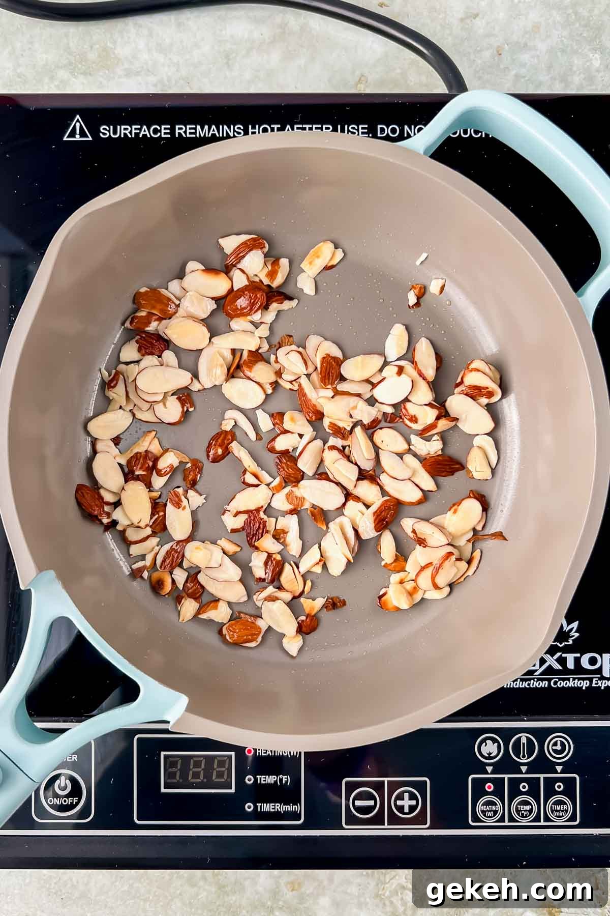 small skillet with toasted shaved almonds on hot plate. 