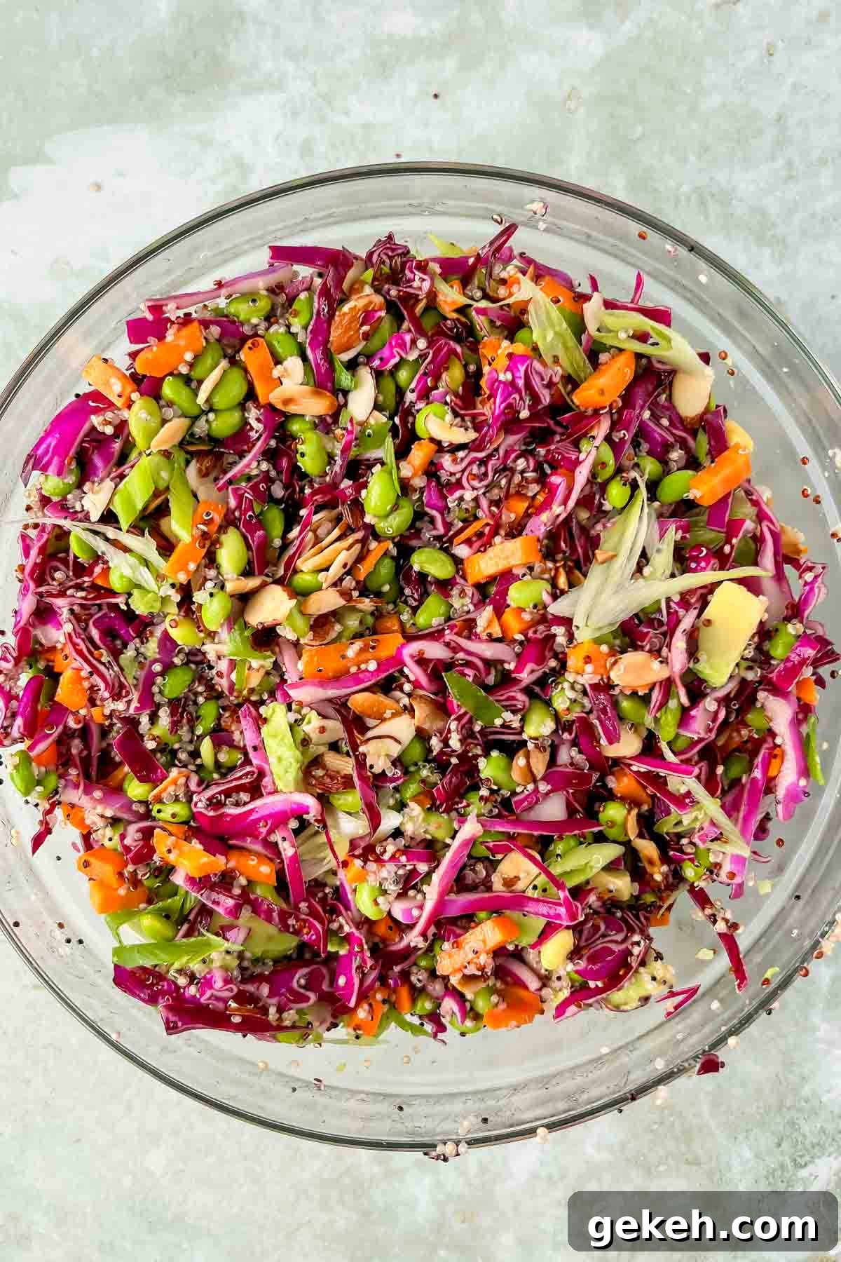 quinoa edamame salad tossed together in large glass mixing bowl. 