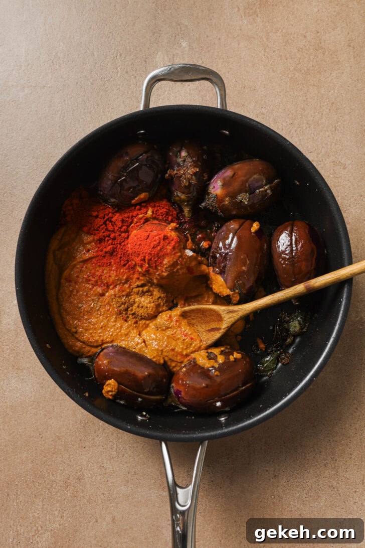 Bagara Baingan: Authentic South Indian Eggplant Curry Recipe 13 Tomato paste, ground spices and salt added to skillet with eggplant.