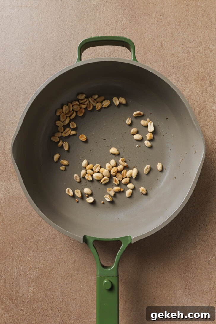 Bagara Baingan: Authentic South Indian Eggplant Curry Recipe 8 Toasting peanuts in a skillet to make Bagare Baingan.