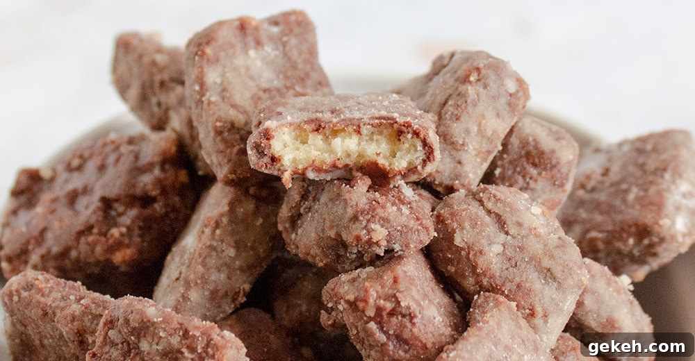 Keto Puppy Chow Recipe: Low-Carb Muddy Buddies Snack 8 side view of pile of keto puppy chow with bite taken out of one piece on top