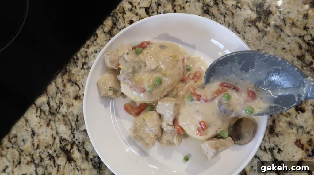Ladling chicken and sauce over biscuits.