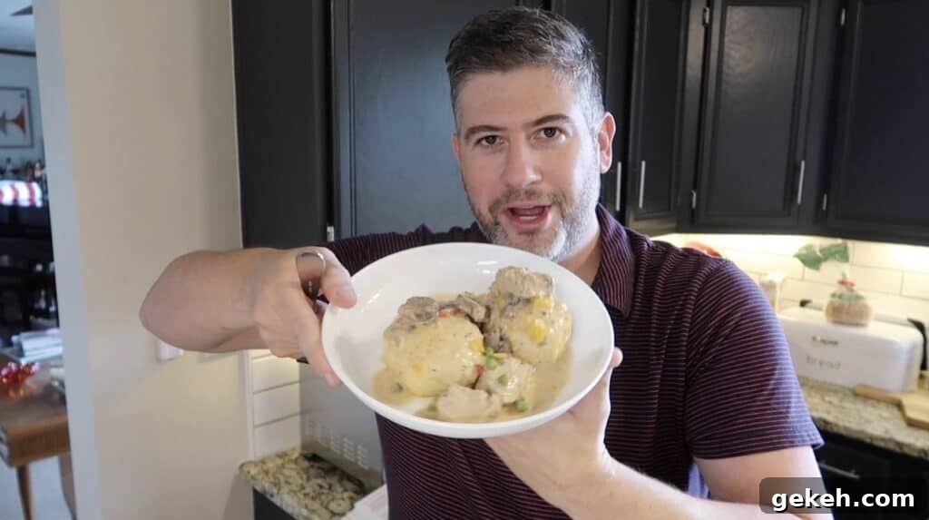 Man holding bowl of finished Chicken a la Queens
