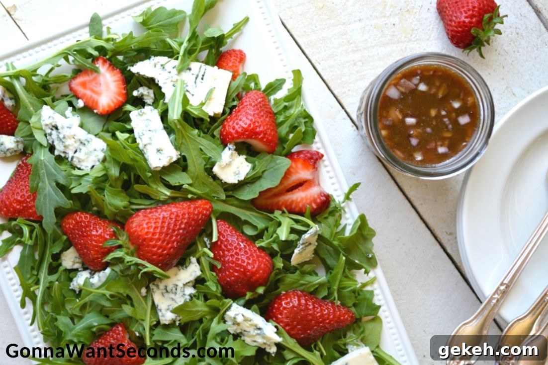 Strawberry Salad with a jar of homemade vinaigrette on the side