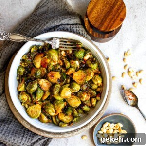 Honey Sriracha Brussels Sprouts Recipe: Sweet-Spicy Roasted Veggies 8 White bowl filled with brussel sprouts and sauce and a silver spoon with sauce. Peanuts on the side.