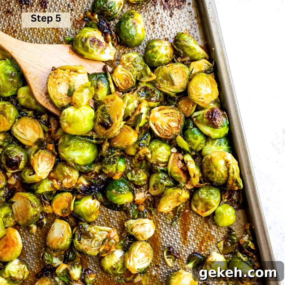 Honey Sriracha Brussels Sprouts Recipe: Sweet-Spicy Roasted Veggies 6 Brussel sprouts on a baking sheet with sriracha and honey sauce.