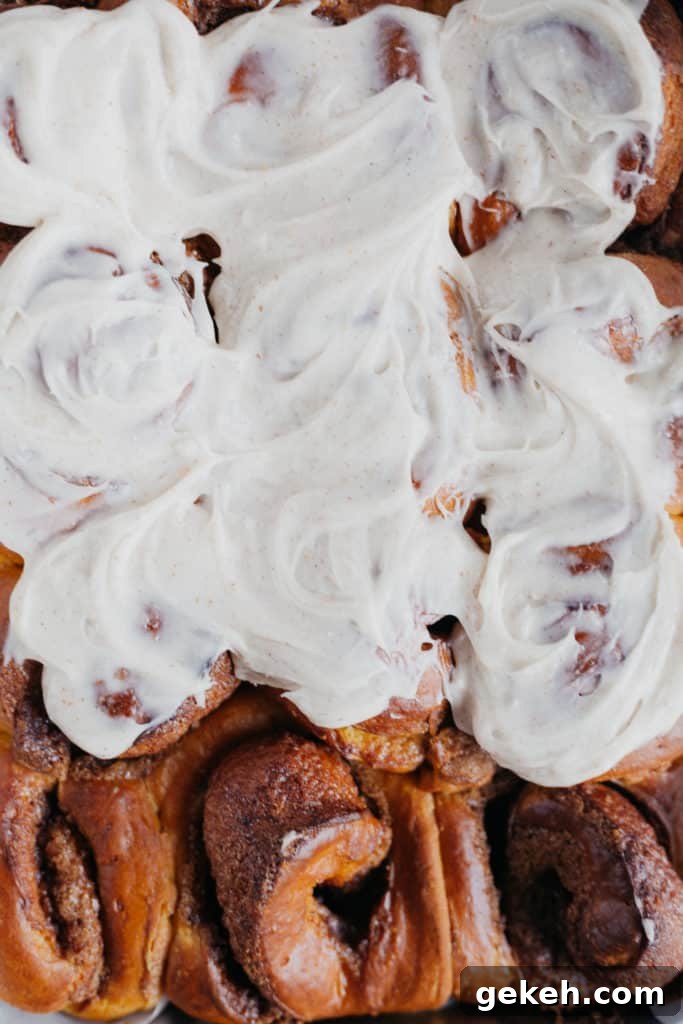 Pumpkin Cinnamon Rolls with Brown Butter Frosting Recipe 2 overhead view of pumpkin cinnamon rolls, covered in frosting