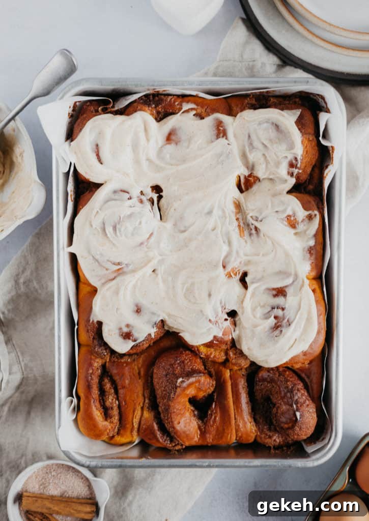 Pumpkin Cinnamon Rolls with Brown Butter Frosting Recipe 3 overhead view of pumpkin cinnamon rolls, 9 of them frosted.