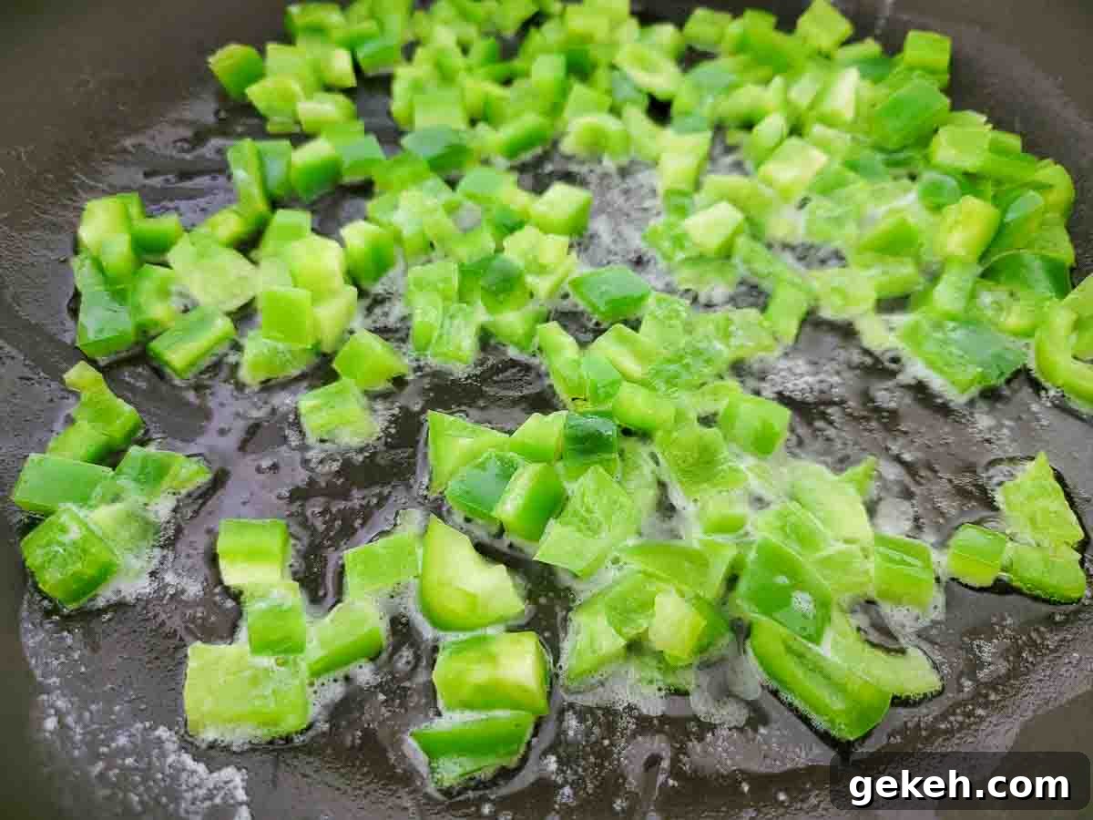 Savory Spam and Scrambled Eggs Recipe for Quick Breakfast 3 diced green peppers cooking in a skillet.