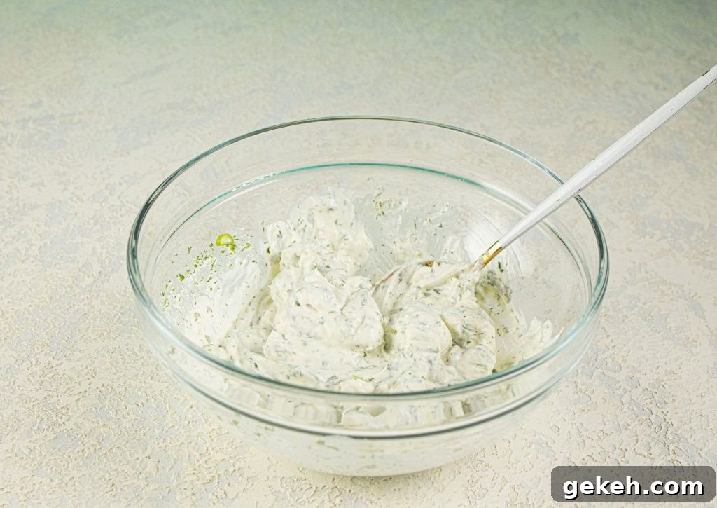 Refreshing Cucumber and Dill Tea Sandwiches for Entertaining 5 Cream cheese and seasonings being mixed in a bowl.