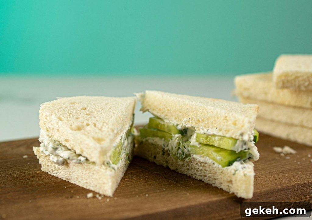 Refreshing Cucumber and Dill Tea Sandwiches for Entertaining 8 Sandwich being cut on a wooden cutting board.