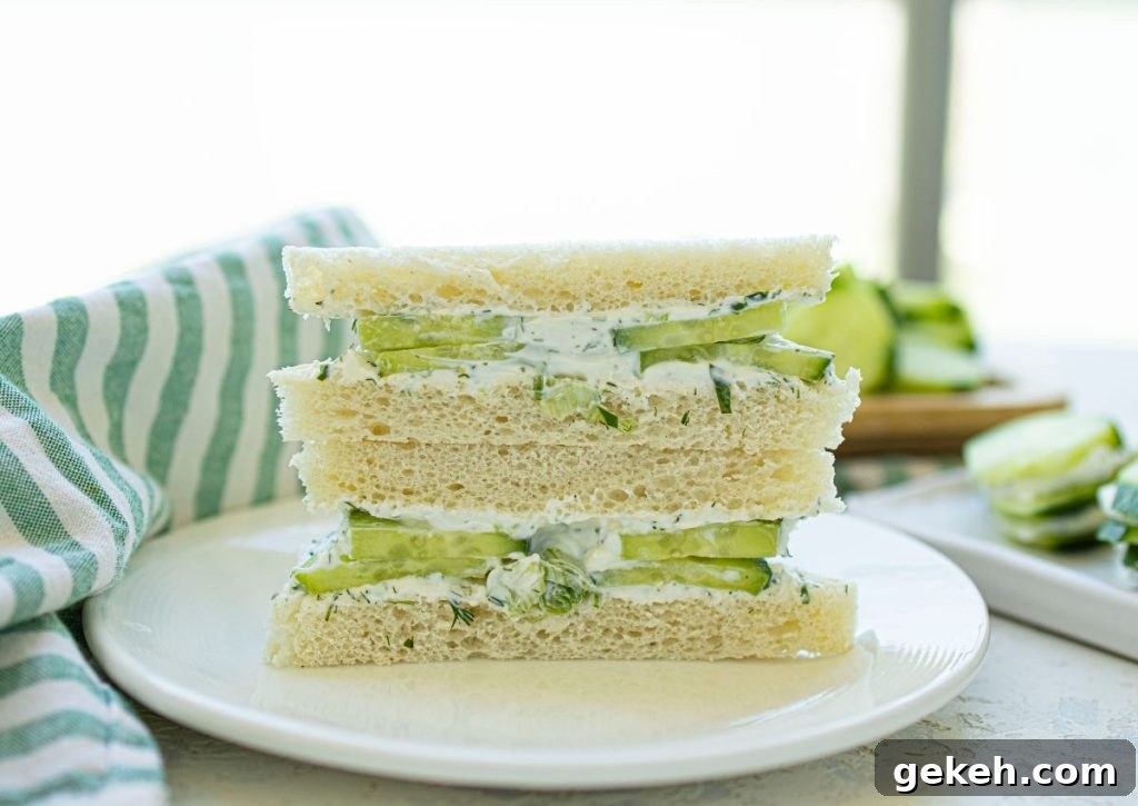 Refreshing Cucumber and Dill Tea Sandwiches for Entertaining 9 Two halves of cucumber and dill sandwiches stacked on a plate.