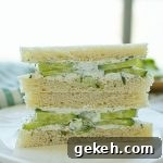 Refreshing Cucumber and Dill Tea Sandwiches for Entertaining 10 Two halves of cucumber and dill sandwiches stacked on a plate.