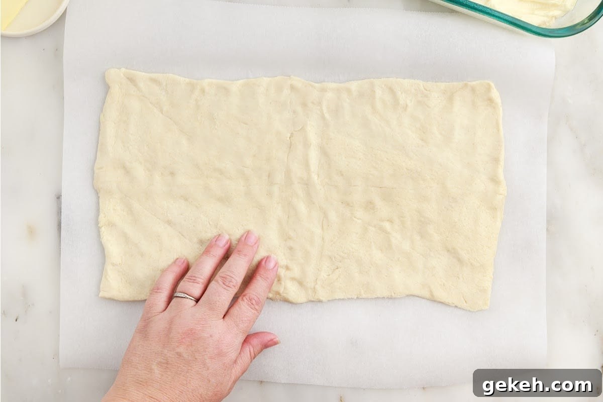 Crescent rolls rolled out onto parchment paper.