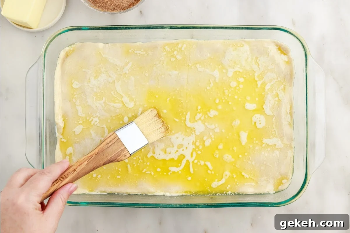 Melted butter spread on the top of the Sopapilla Cheesecake with a brush.
