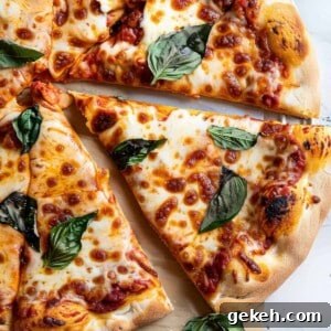 Margherita pizza with basil and mozzarella on a marble table.