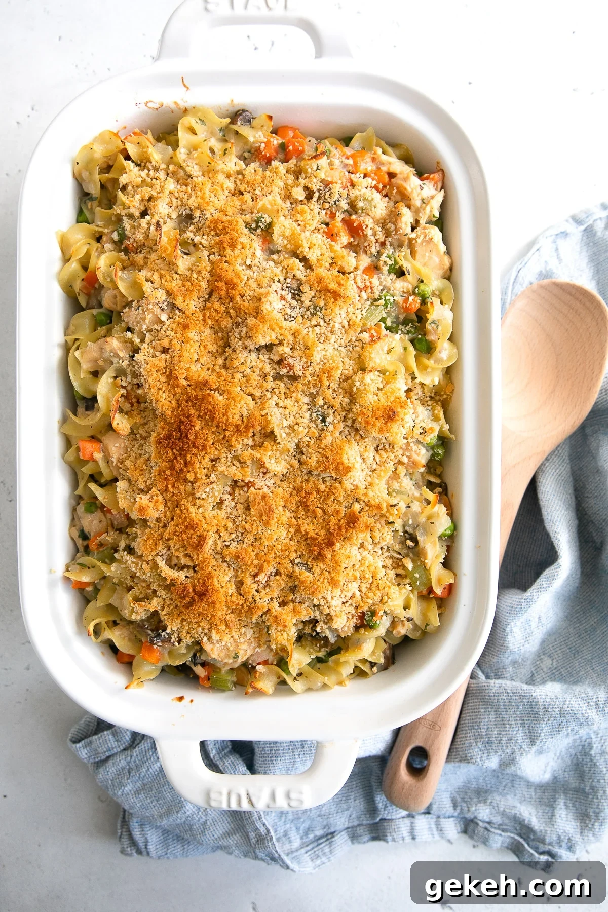 Classic Tuna Noodle Casserole Recipe for Comforting Weeknight Meals 3 White baking dish filled with tuna noodle casserole and topped with crushed whole wheat Ritz crackers and butter.
