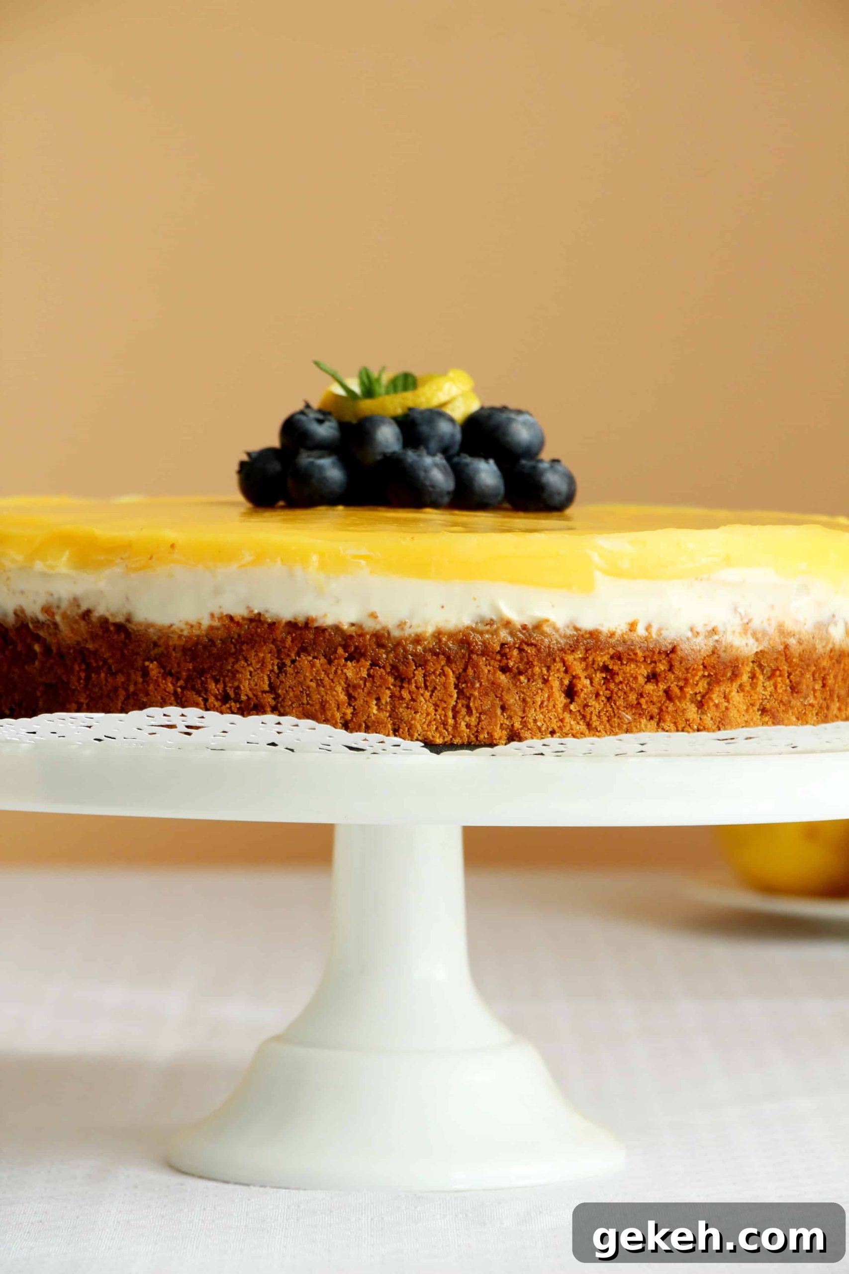 Creamy Lemon Cheesecake Recipe: Zesty Slice of Perfection 2 lemon cheesecake on white cake stand