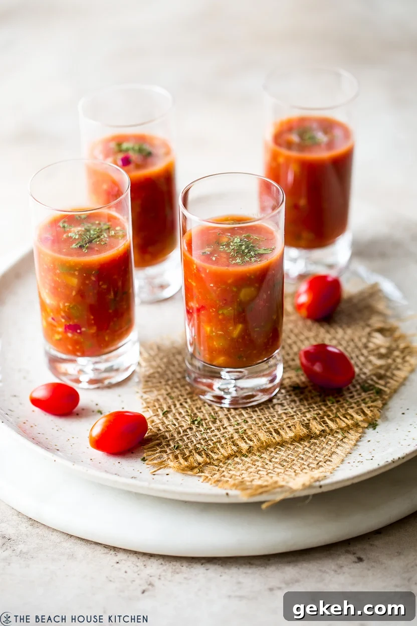 Authentic Spanish Gazpacho Recipe: Refreshing Cold Tomato Soup 2 Four shooters glasses filled with gazpacho of a round marble board