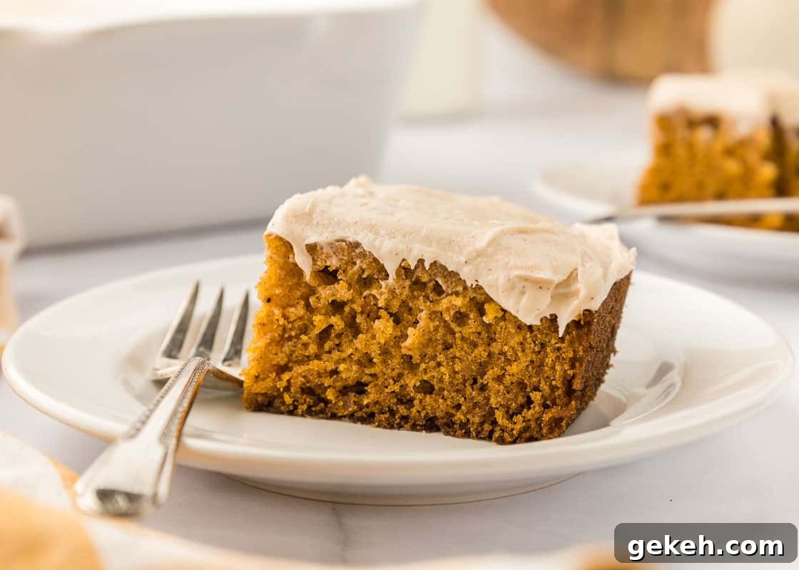 Moist Pumpkin Sheet Cake Recipe with Cream Cheese Frosting 22 A slice of pumpkin cake on a plate with a fork.