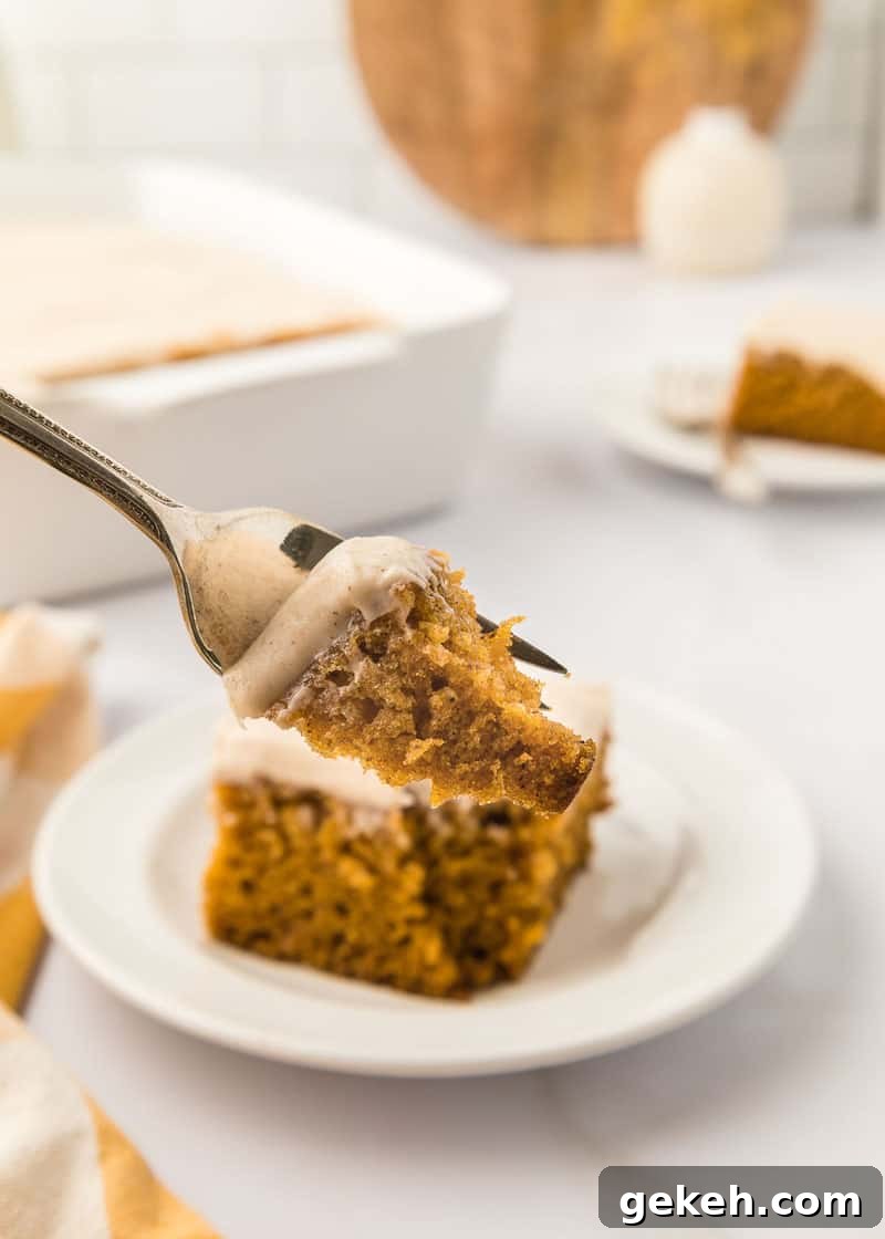 Moist Pumpkin Sheet Cake Recipe with Cream Cheese Frosting 5 A piece of pumpkin cake on a plate with a fork.