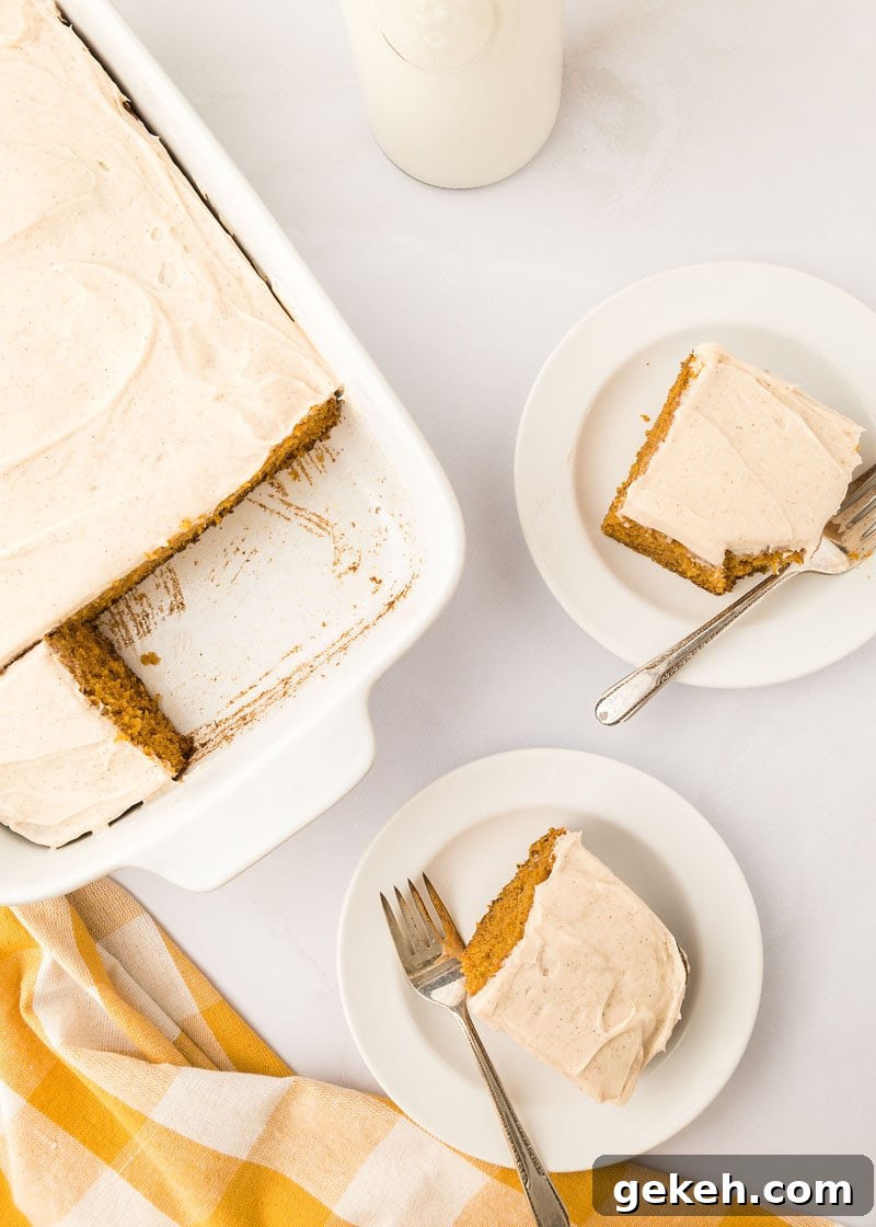 Moist Pumpkin Sheet Cake Recipe with Cream Cheese Frosting 6 Two slices of pumpkin cake with frosting on white plates with forks.