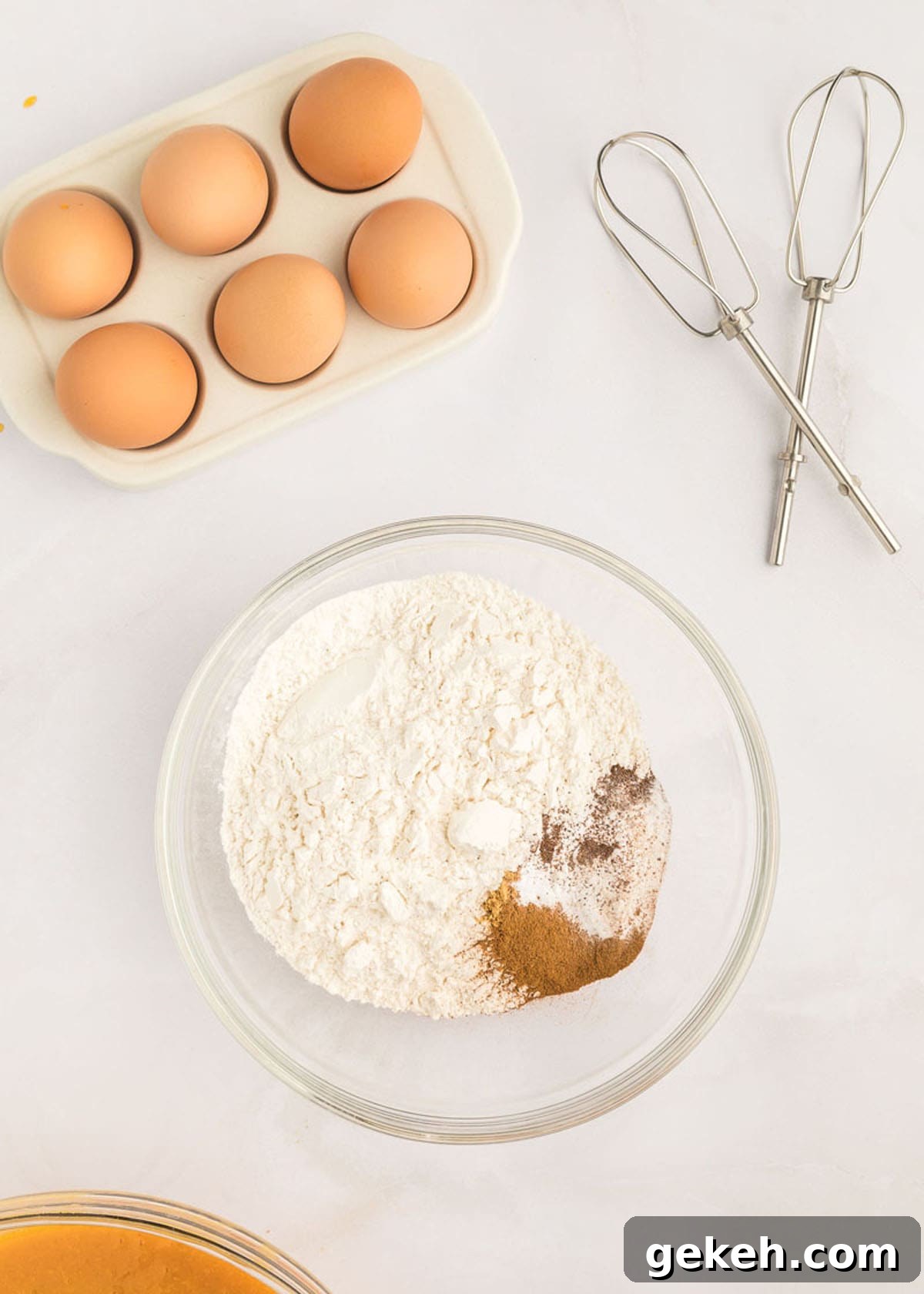 Moist Pumpkin Sheet Cake Recipe with Cream Cheese Frosting 10 A bowl of flour, eggs, and pumpkin cake spices.