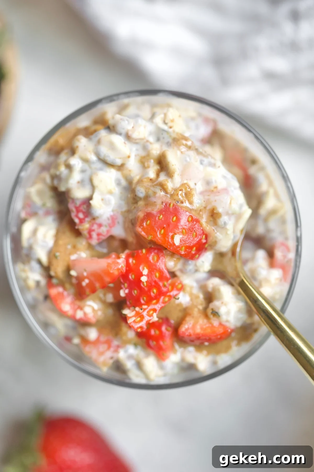 cup of oatmeal with strawberries and spoon