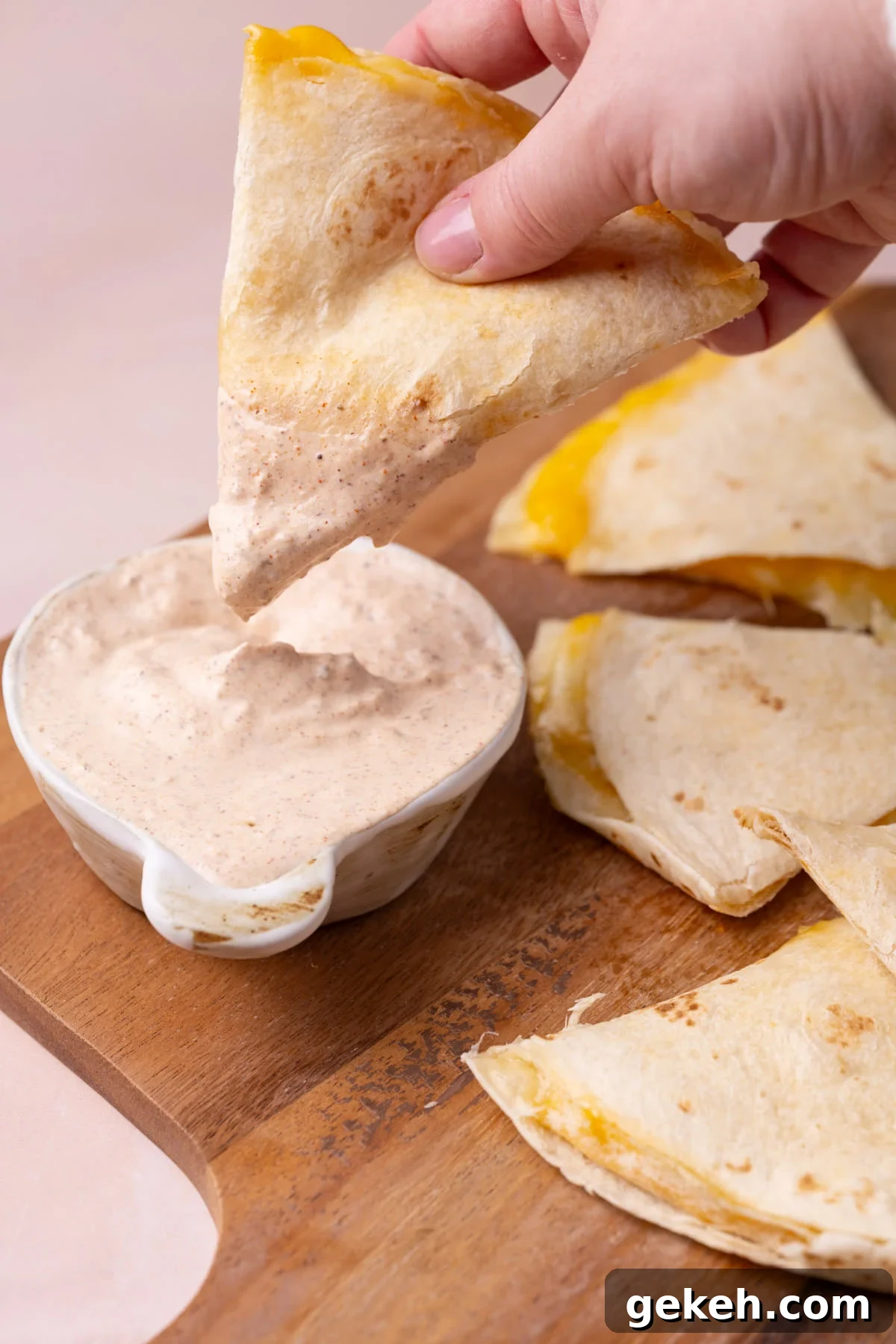 Creamy 3-Ingredient Quesadilla Sauce Recipe 5 Dipping a piece of a cheese quesadilla into homemade sauce.