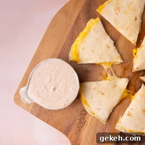 Creamy 3-Ingredient Quesadilla Sauce Recipe 6 Overhead image of a small bowl of sauce next to a cheesy quesadilla.
