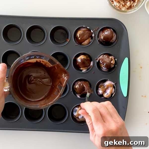 Pouring chocolate over the blueberry yogurt mixture in the muffin cups.
