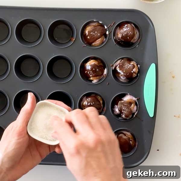 Sprinkling sea salt on top of the melted chocolate clusters.