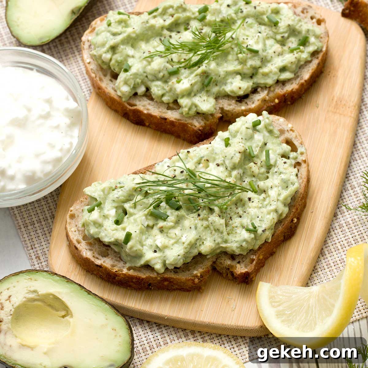 Two slices of cottage cheese avocado toast on a cutting board.
