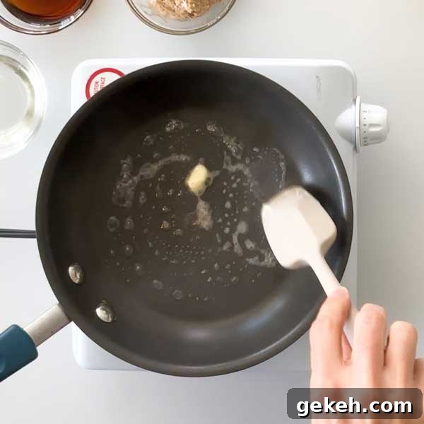 Adding butter to a skillet to toast the coconut.