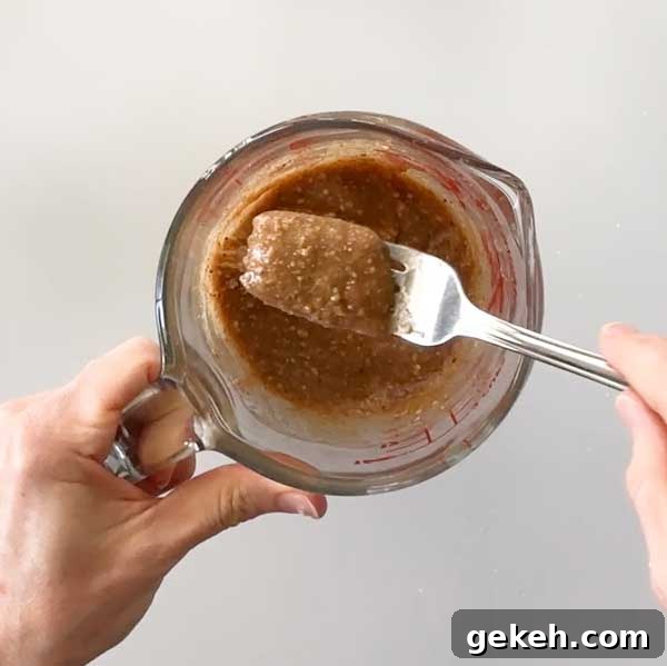 Mixing the caramel with a fork in a measuring glass.