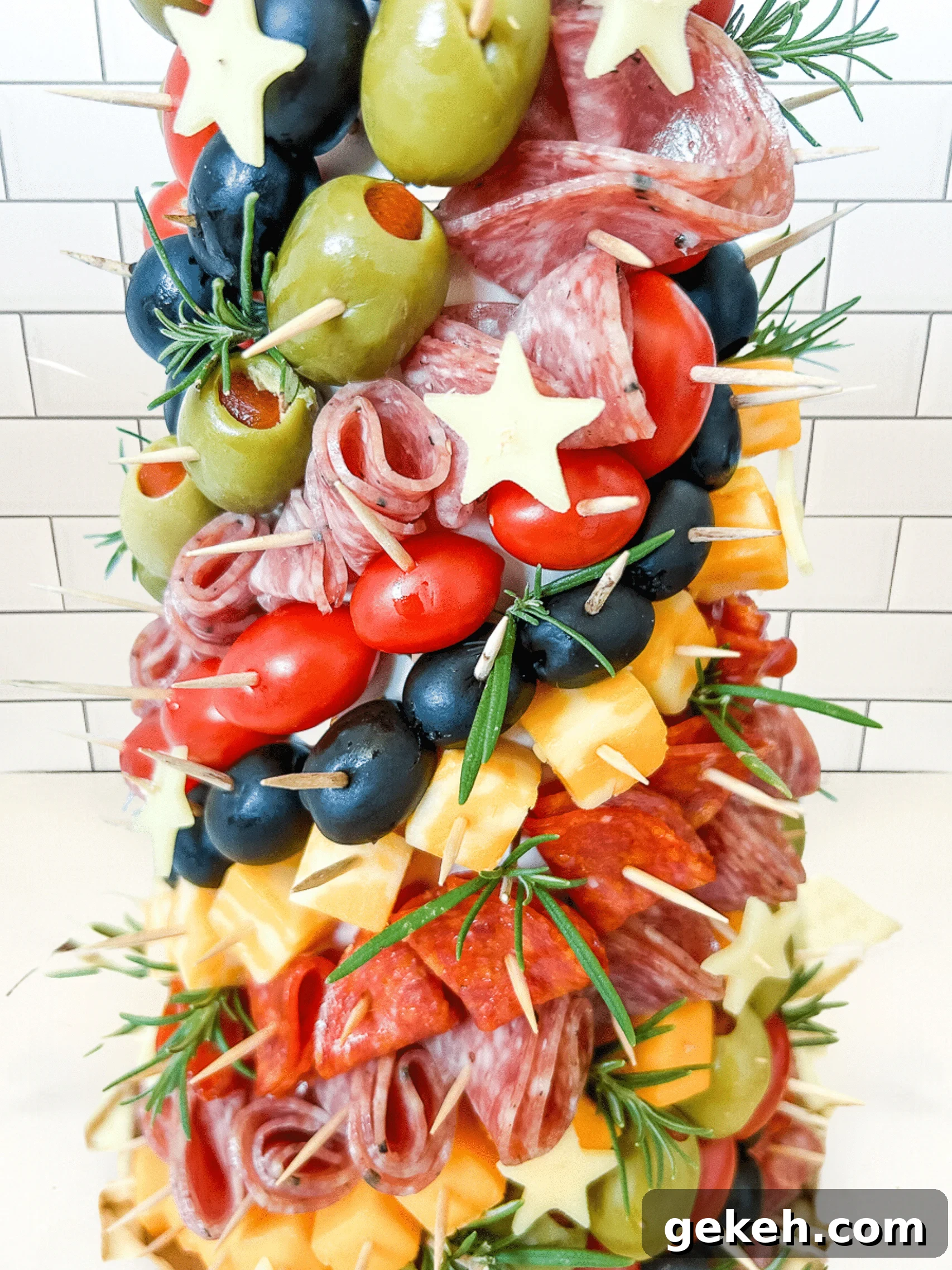 Festive Charcuterie Tree Guide: How to Build a Showstopping Holiday Platter 3 Close up of a charcuterie tree with meats, cheeses, olives, and stars stuck into a styrofoam cone with toothpicks.