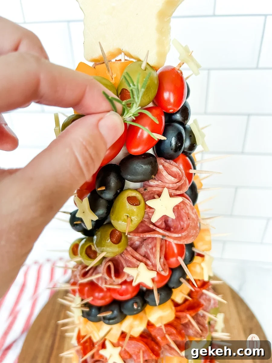 Festive Charcuterie Tree Guide: How to Build a Showstopping Holiday Platter 8 Placing a sprig of rosemary in the tree.