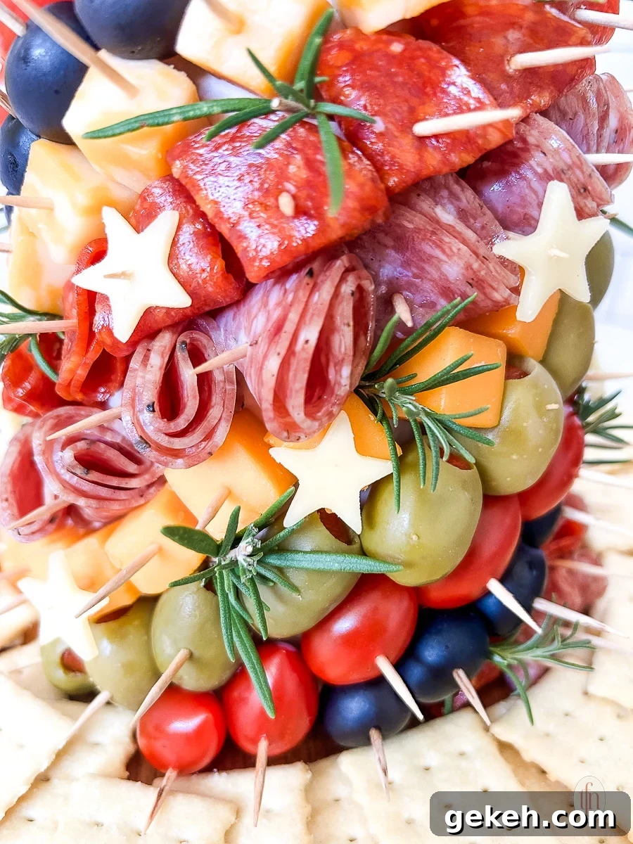Festive Charcuterie Tree Guide: How to Build a Showstopping Holiday Platter 10 Close up of a charcuterie tree with meats, cheeses, olives, and stars stuck into a styrofoam cone with toothpicks.