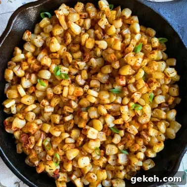 Perfectly Sautéed Summer Squash with Garlic and Herbs 8 A close-up of blackened, sautéed corn kernels garnished with fresh green onions, served in a cast iron skillet.
