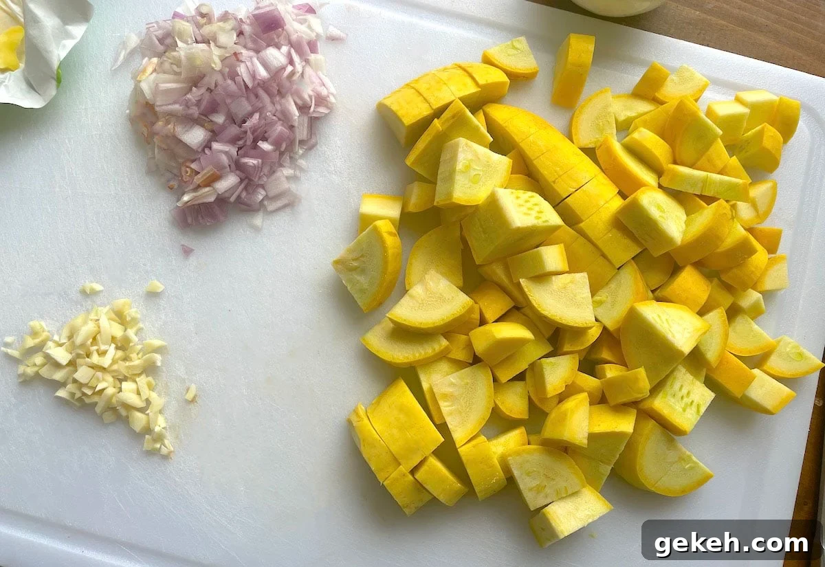 Perfectly Sautéed Summer Squash with Garlic and Herbs 4 Diced yellow squash, garlic, and shallots on a white cutting board.