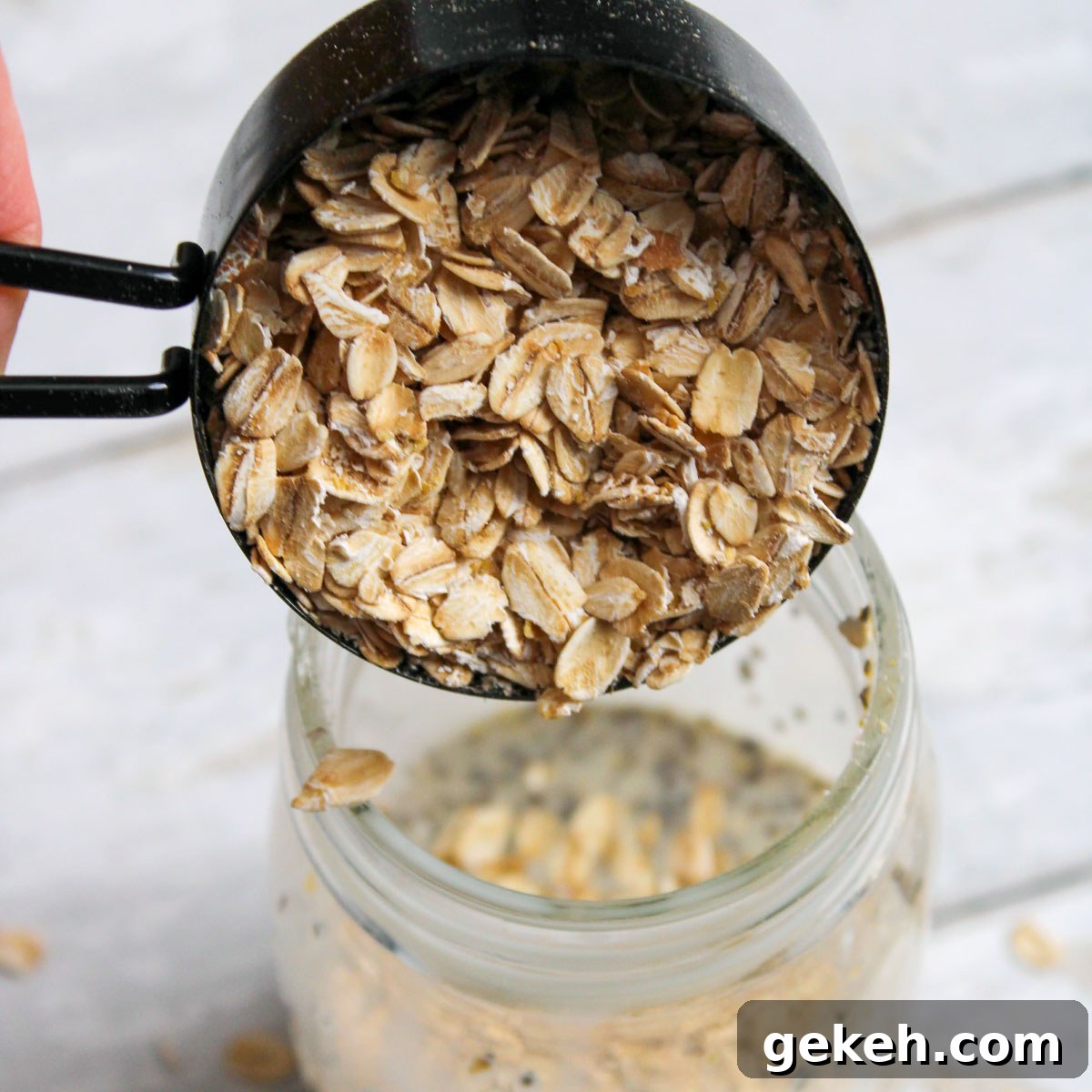 Creamy Peanut Butter Overnight Oats Recipe for Quick Breakfast 6 Rolled oats being added to the mason jar with the mixed liquid.