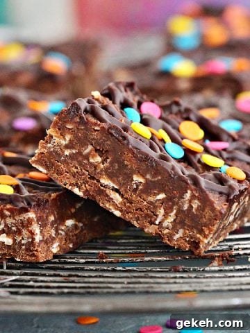 Close up of squares of chocolate no-bake oat bars with confetti on a wire rack.