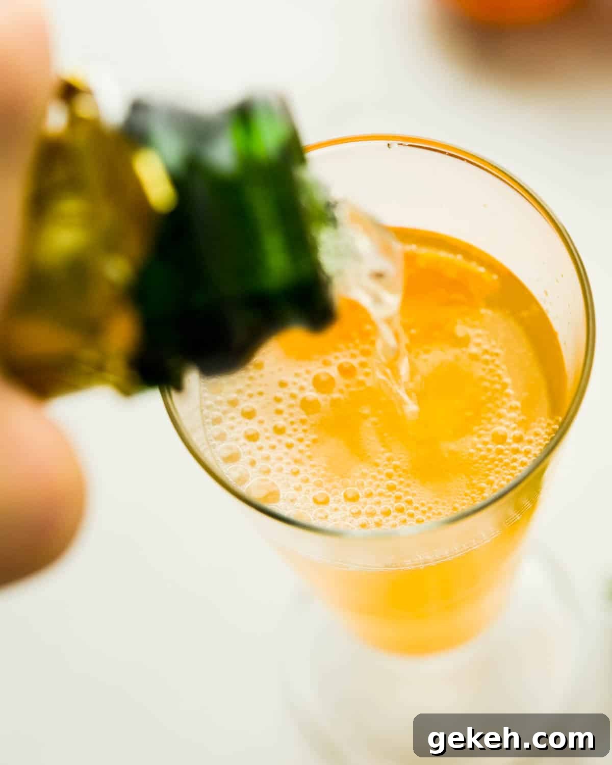 Topping off the brunch drink with sparkling wine.