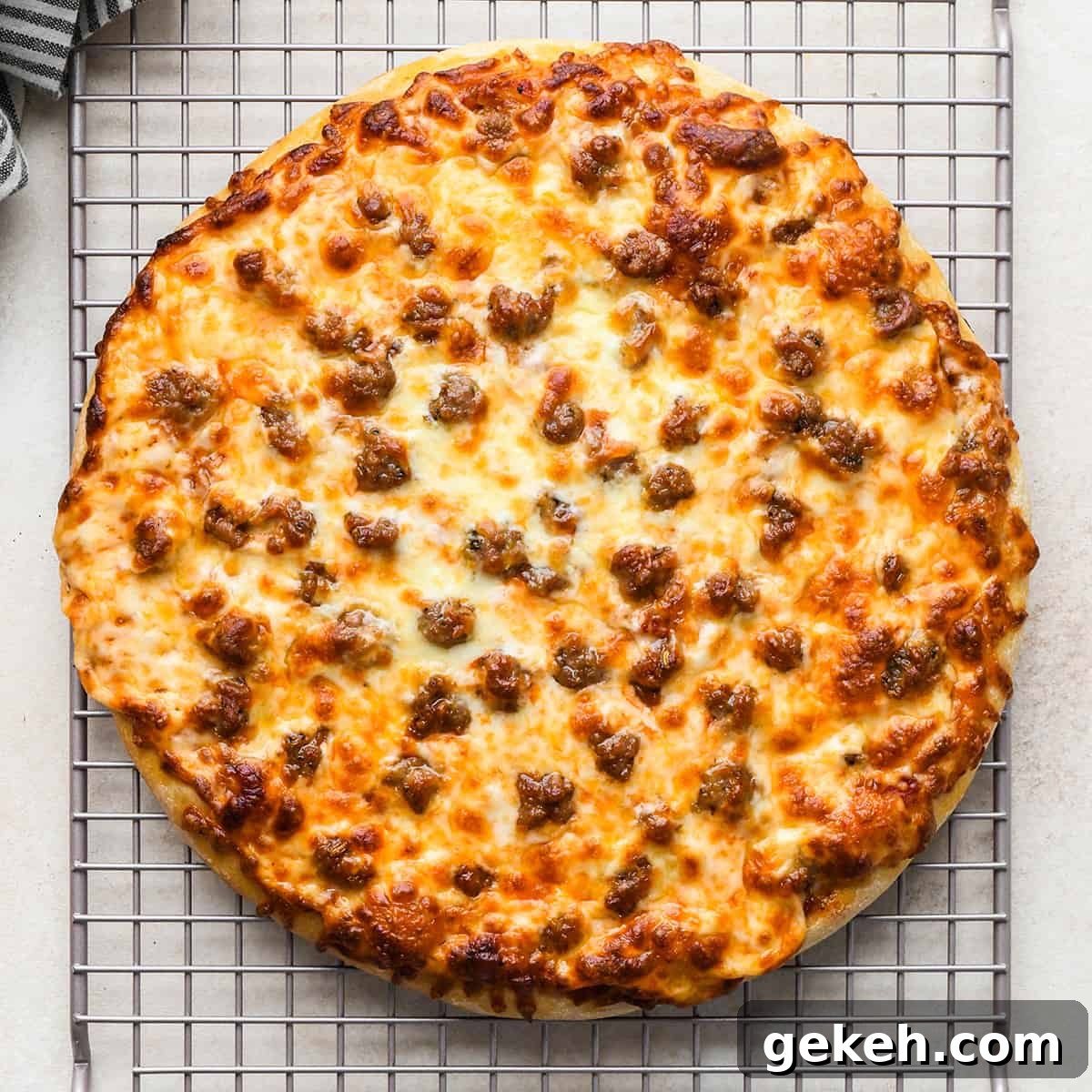 Classic Sausage Pizza Recipe: Crispy Crust & Savory Toppings 14 a round Sausage Pizza on a wire cooling rack
