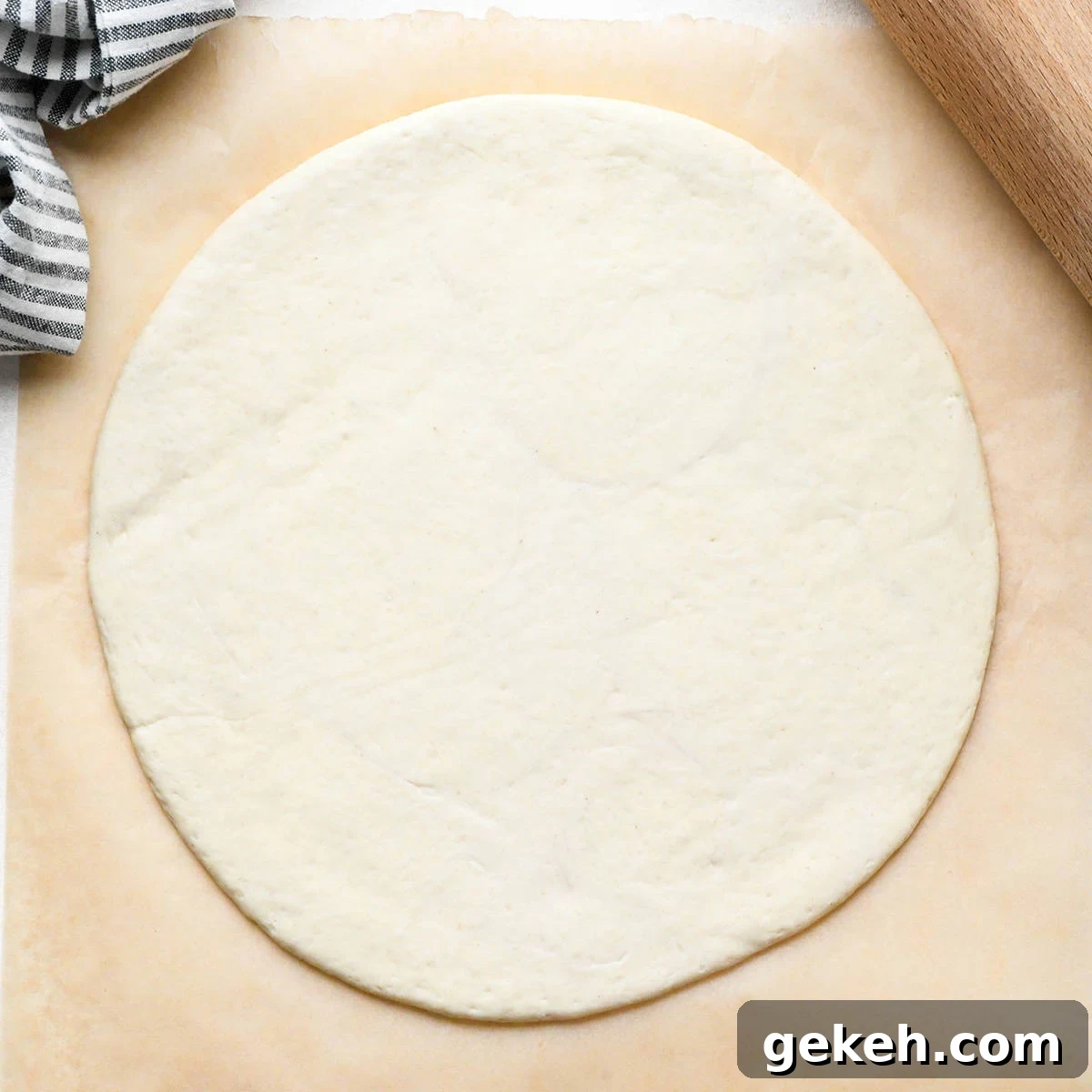 Classic Sausage Pizza Recipe: Crispy Crust & Savory Toppings 8 pizza dough rolled into a circle on a piece of parchment paper
