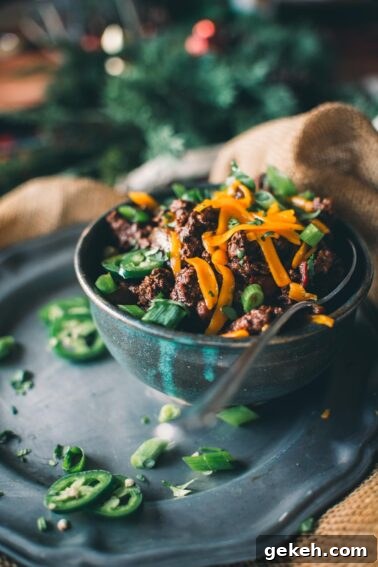 Grilled Elk Steaks: Juicy Elk Steak Recipe and Cooking Tips 11 A bowl of venison chili topped with sliced green onions and shredded cheese, garnished with jalapeño slices.