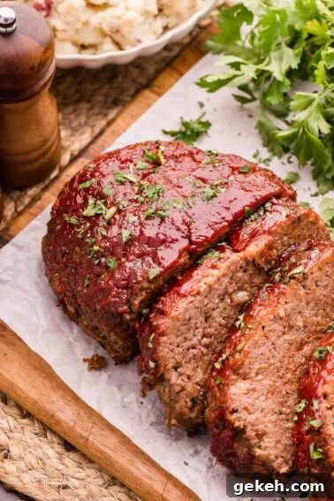 Grilled Elk Steaks: Juicy Elk Steak Recipe and Cooking Tips 8 Sliced bison meatloaf with tomato glaze and chopped herbs on parchment paper, with parsley and a pepper grinder in the background.