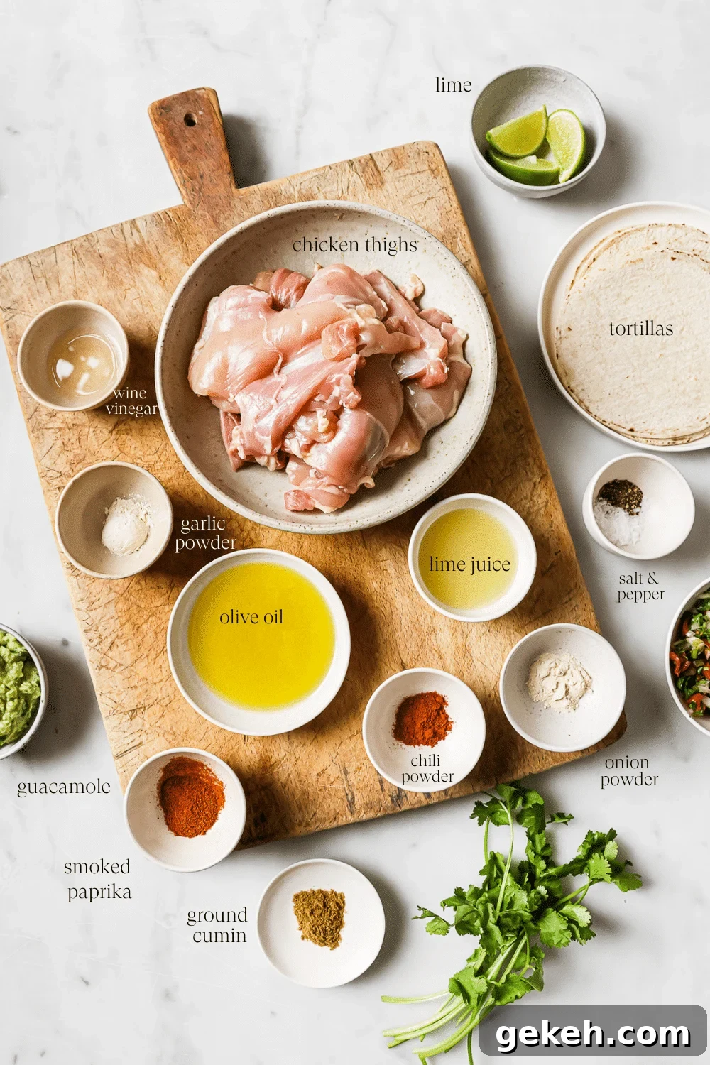 Chicken Tacos with Savory Homemade Marinade 3 Bowls of prepped ingredients on a wooden cutting board and white countertop.