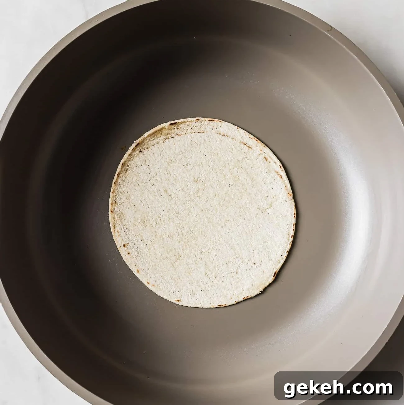 Chicken Tacos with Savory Homemade Marinade 8 A corn tortilla in the middle of a large skillet.
